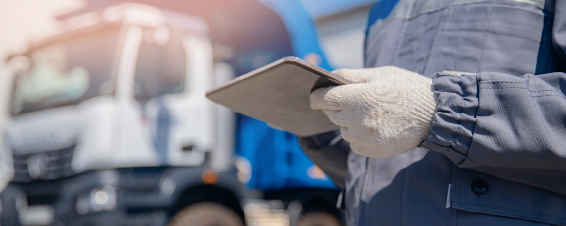 Driver holding documents to sign in front of his truck